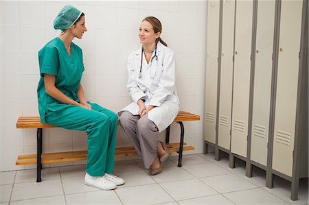 Doctor and a nurse sitting on a bench speaking Photographie de stock - Premium Libres de Droits, Code: 6109-06684700