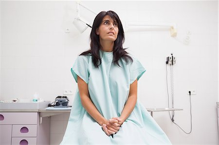 patient gown - Patient looking up while sitting on a table Stock Photo - Premium Royalty-Free, Code: 6109-06684707