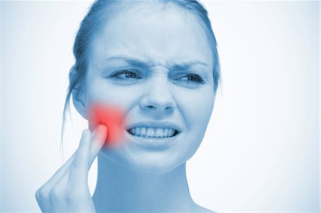 simsearch:6109-06684724,k - Woman touching highlighted red toothache Stock Photo - Premium Royalty-Free, Code: 6109-06684714
