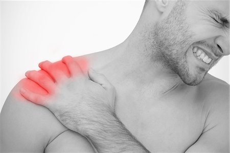 explícito - Man wincing in pain at sore shoulder Foto de stock - Sin royalties Premium, Código: 6109-06684723