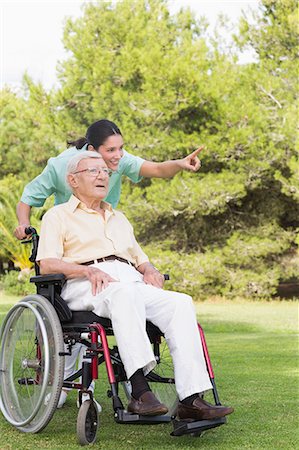 simsearch:6109-06684830,k - Nurse pointing to something with man in wheelchair Stock Photo - Premium Royalty-Free, Code: 6109-06684840