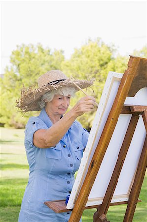 Woman wearing straw hat painting in the park Photographie de stock - Premium Libres de Droits, Code: 6109-06684850