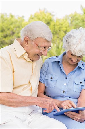 simsearch:6109-06684830,k - Smiling elderly couple using tablet in the park Stock Photo - Premium Royalty-Free, Code: 6109-06684823