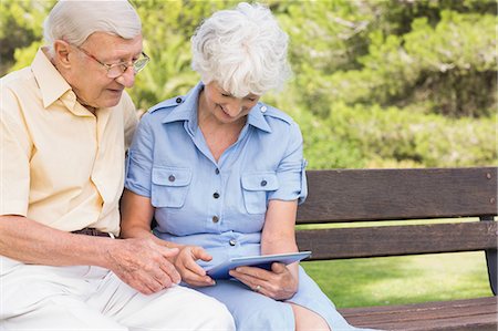 simsearch:6109-06684838,k - Smiling elderly couple using tablet in the park Foto de stock - Sin royalties Premium, Código: 6109-06684824