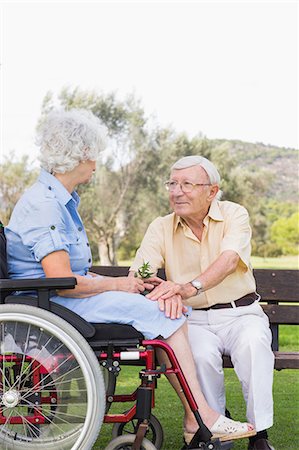 simsearch:6109-06684830,k - Elderly man talking to his partner in a wheelchair in the park Stock Photo - Premium Royalty-Free, Code: 6109-06684829