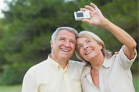 simsearch:6109-06684830,k - Older couple taking a photo of themselves and smiling Stock Photo - Premium Royalty-Free, Code: 6109-06684903