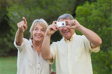 simsearch:6109-06684830,k - Couple taking a photo of something in the park Stock Photo - Premium Royalty-Free, Code: 6109-06684905