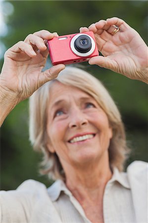 photographier - Older blonde woman taking a photo Photographie de stock - Premium Libres de Droits, Code: 6109-06684911