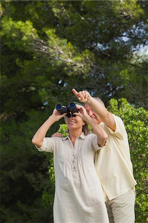 simsearch:6109-06684830,k - Happy older couple with binoculars with man pointing Stock Photo - Premium Royalty-Free, Code: 6109-06684929