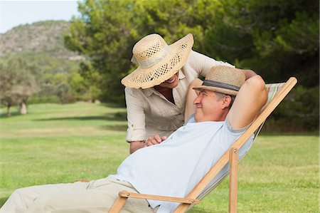 deckchair garden - Older man relaxing in deck chair with his partner saying hello Stock Photo - Premium Royalty-Free, Code: 6109-06684933