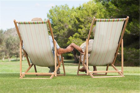 simsearch:6109-06684830,k - Couple in deck chairs holding hands Stock Photo - Premium Royalty-Free, Code: 6109-06684934