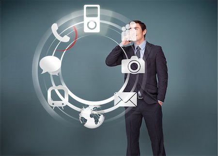 social media - Businessman on the phone looking at wheel of applications Stock Photo - Premium Royalty-Free, Code: 6109-06685041