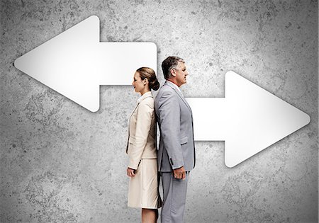 Business partners standing back to back on wall with arrows Stock Photo - Premium Royalty-Free, Code: 6109-06685002