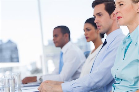simsearch:6109-06781334,k - Serious business people sitting in line Stock Photo - Premium Royalty-Free, Code: 6109-06781345