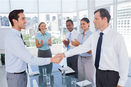 simsearch:6109-06781339,k - Smiling business people shaking their hands Foto de stock - Sin royalties Premium, Código: 6109-06781358