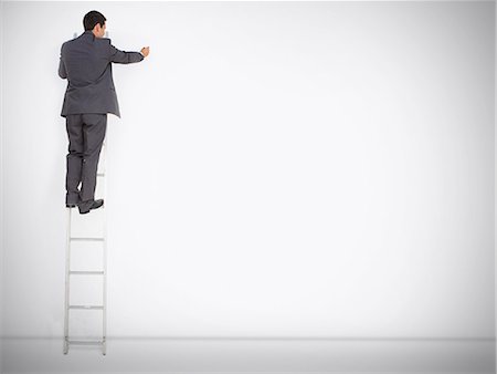 Businessman standing on ladder drawing on large copy space Photographie de stock - Premium Libres de Droits, Code: 6109-06781457