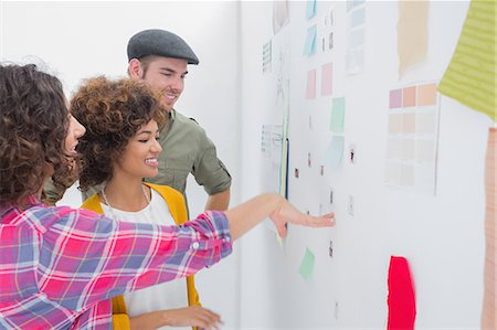 professionals whiteboard - Young team of designers working together and pointing at a wall Stock Photo - Premium Royalty-Free, Code: 6109-06781493