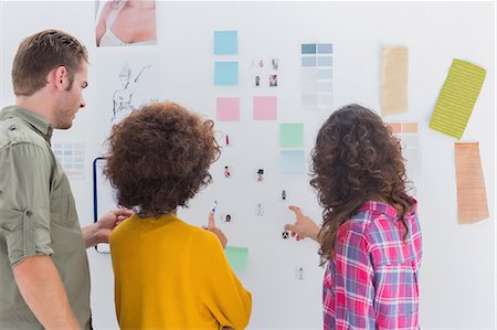 Team of designers working together and pointing at a wall Photographie de stock - Premium Libres de Droits, Code: 6109-06781491