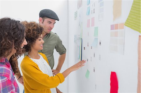 Smiling team of designers working together and pointing at a wall Photographie de stock - Premium Libres de Droits, Code: 6109-06781492