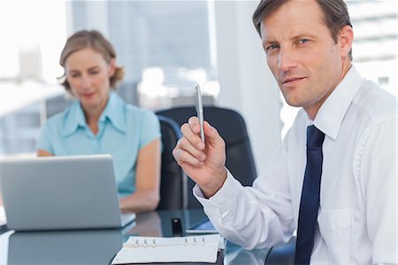 swivel chair - Business man holding a pen Stock Photo - Premium Royalty-Free, Code: 6109-06781408