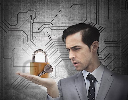 Concentrated businessman holding a padlock Foto de stock - Sin royalties Premium, Código: 6109-06781419