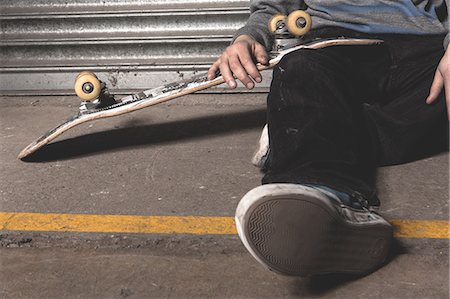 simsearch:6109-06781429,k - Skater sitting on ground with board Foto de stock - Royalty Free Premium, Número: 6109-06781430