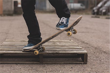 skateboard - Skater doing manual trick on wooden crate Stock Photo - Premium Royalty-Free, Code: 6109-06781436