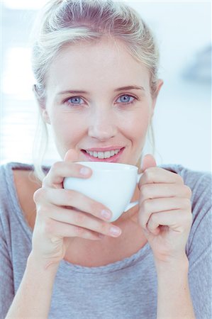 person drinking cup of coffee - Smiling woman holding a cup of tea Stock Photo - Premium Royalty-Free, Code: 6109-06781545