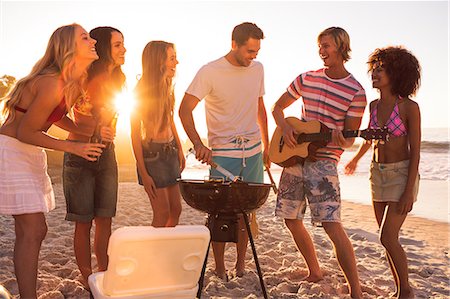 friends enjoying pictures - Group of friends playing guitar on the beach Stock Photo - Premium Royalty-Free, Code: 6109-06781571