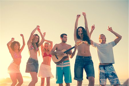 Group of friends having fun on the beach and playing guitar Foto de stock - Sin royalties Premium, Código: 6109-06781581