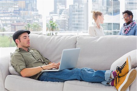simsearch:6109-06781494,k - Worker using his laptop while laying on a couch Stock Photo - Premium Royalty-Free, Code: 6109-06781501