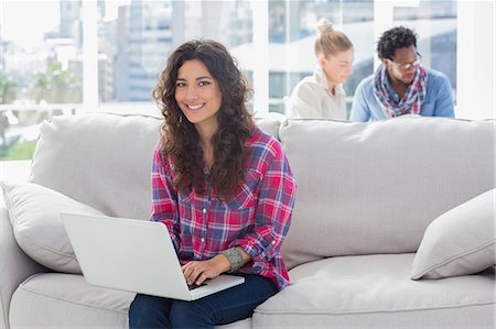 simsearch:6109-06781494,k - Smiling worker using laptop while sitting on a couch Stock Photo - Premium Royalty-Free, Code: 6109-06781510