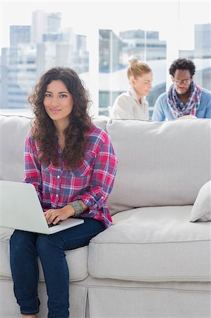 simsearch:6109-06781494,k - Attractive worker using laptop while sitting on a couch Stock Photo - Premium Royalty-Free, Code: 6109-06781511