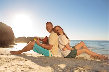 simsearch:6109-06781578,k - Couple sat back to back on the beach Stock Photo - Premium Royalty-Free, Code: 6109-06781674