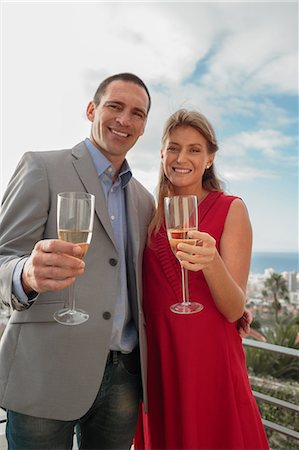 sophisticated man in suit with drink - Couple clinking their glass of champagne Stock Photo - Premium Royalty-Free, Code: 6109-06781612