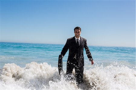suit (man's) - Cheerful businessman walking in the sea Stock Photo - Premium Royalty-Free, Code: 6109-06781635
