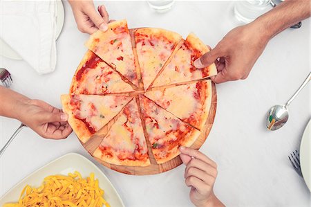 Hands taking slice of pizzas Foto de stock - Royalty Free Premium, Número: 6109-06781745