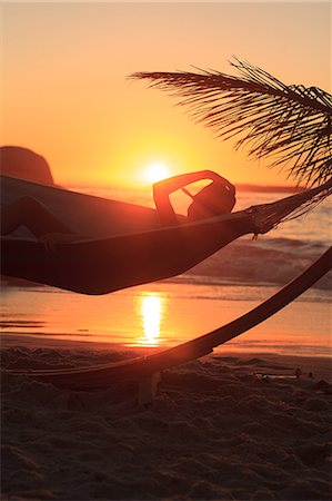 simsearch:6109-06781824,k - A person wearing a straw hat and relaxing in hammock on the beach Stock Photo - Premium Royalty-Free, Code: 6109-06781791