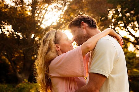 Cheerful couple about to kiss in a park Stock Photo - Premium Royalty-Free, Code: 6109-06781724