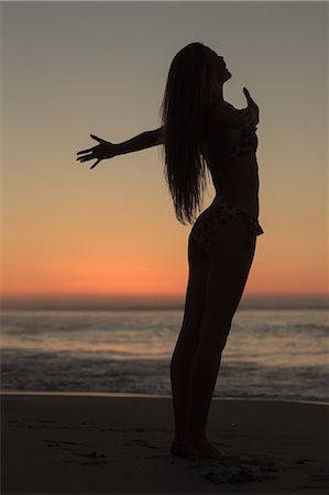 fitting - Silhouette of an attractive woman spreading her arms on the beach Stock Photo - Premium Royalty-Free, Code: 6109-06781801