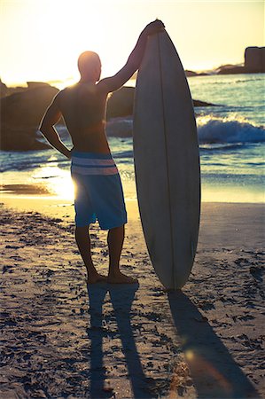 surfing - Attractive surfer standing next to his surfboard Stock Photo - Premium Royalty-Free, Code: 6109-06781811
