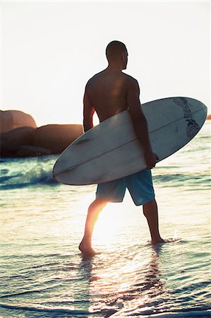 surf sunset - Attractive surfer walking in the sea Stock Photo - Premium Royalty-Free, Code: 6109-06781815