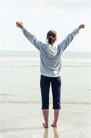 simsearch:6109-07496983,k - Woman on the beach opening her arms in front of the sea Stock Photo - Premium Royalty-Free, Code: 6109-07496974