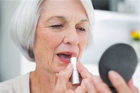 elderly woman beauty - Mature woman using lipstick with compact mirror Stock Photo - Premium Royalty-Free, Code: 6109-07496994