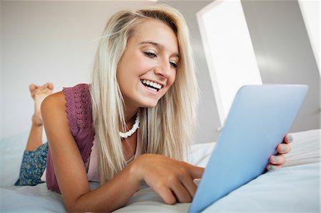 simsearch:6109-07497296,k - Gorgeous cheerful blonde using tablet in bright bedroom Photographie de stock - Premium Libres de Droits, Code: 6109-07497042