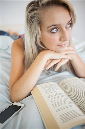 simsearch:6109-07497398,k - Gorgeous thoughtful blonde reading a book in bright bedroom Fotografie stock - Premium Royalty-Free, Codice: 6109-07497056