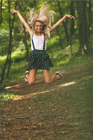 dots leaves - Excited gorgeous blonde jumping in the air in the woods Stock Photo - Premium Royalty-Free, Code: 6109-07497099
