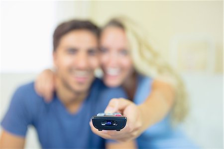 simsearch:400-05748048,k - Smiling young couple watching television in the living room using the remote Stockbilder - Premium RF Lizenzfrei, Bildnummer: 6109-07497367