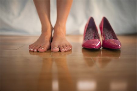 Woman standing beside pink high heels at home in bedroom Foto de stock - Sin royalties Premium, Código: 6109-07497441