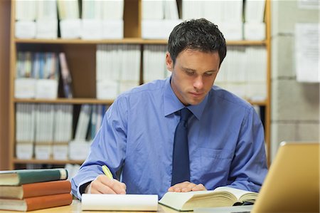 simsearch:6109-07497575,k - Calm librarian taking notes of a book in library in a college Foto de stock - Sin royalties Premium, Código: 6109-07497455